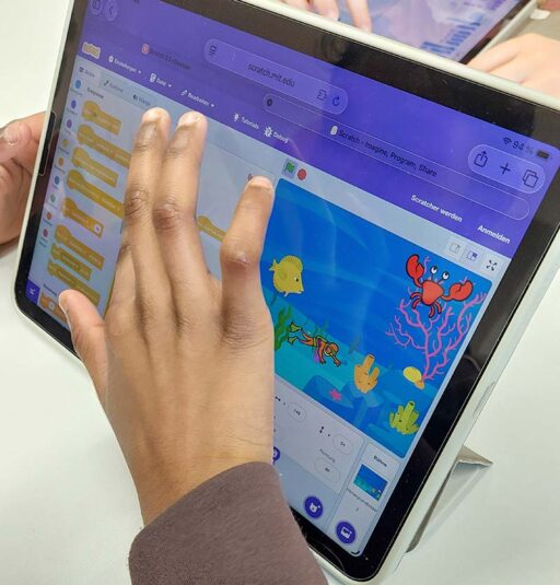 Bildschirm, auf dem eine gezeichnete Unterwasserwelt zu sehen ist. Und eine Hand die den Screen bedient.