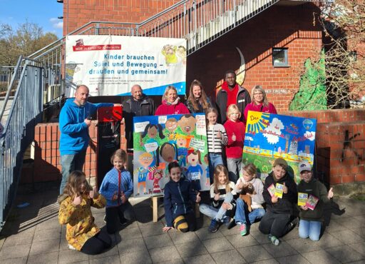 Im Vordergrund Kinder vor ihren gemalten Bildern. Dahinter Erwachsene und die Fahrradreparatursäule vor einem Banner mit dem Text: Kinder brauchen Spiel und Bewegung – draußen und gemeinsam. Im Hintergrund das Gebäude Weiße Rose.