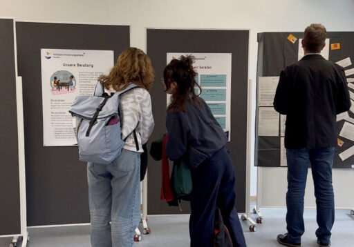 Stellwände mit Plakaten zu Arbeit der Antidiskriminierungsstelle Karlsruhe, davor Besucher*innen