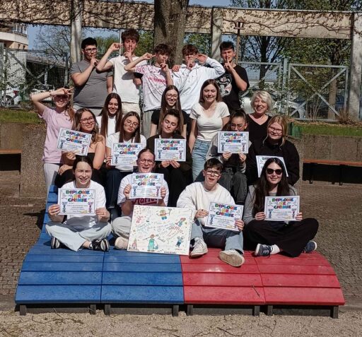 Gruppenfoto mit einer Erwachsenen und Jugendlichen, die ein "Diplome de Chimie" in Händen halten.
